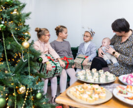 arbre de noël en entreprise, jeune femme en compagnie de trois enfant et d'un bébé traiteur buffet cocktail